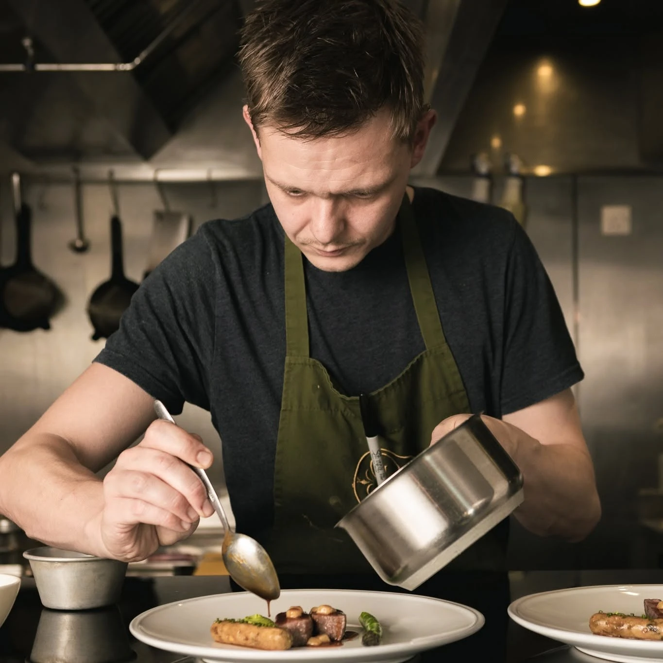 Chris Archer carefully finishing a dish in the kitchen at Pentonbridge Inn